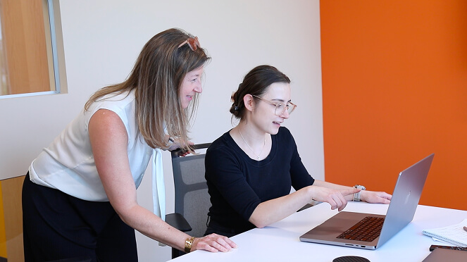 Two women working at a laptop