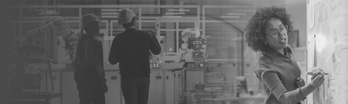 Woman at whiteboard in front of factory workers
